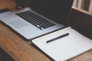 Organized workspace with a laptop and a note book