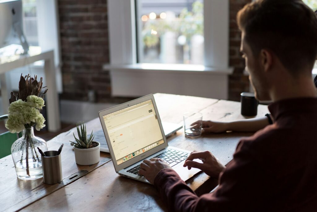 Person optimizing website title tags and meta descriptions on a laptop to improve SEO click-through rates.