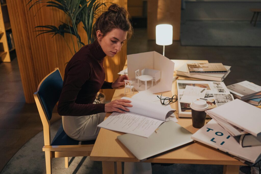 Business owner looking over messy desk with papers and laptops