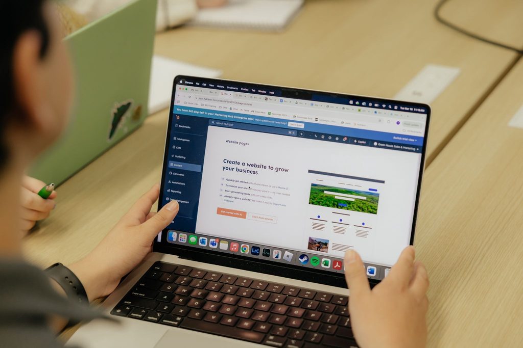 Green House team member building a client website in HubSpot's website builder on a laptop