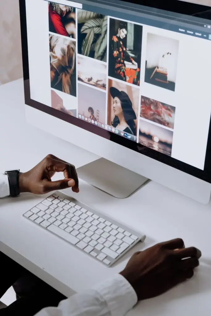 Designer browsing a stock photo site on a desktop computer to choose images for a website